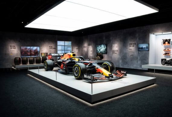 A Red Bull Formula 1 car on display at the Formula 1 exhibition in Amsterdam. The walls of the room highlight different innovations developed by famous Formula 1 teams.