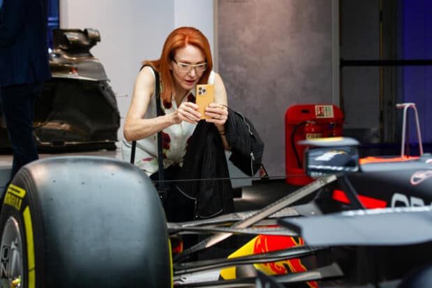 A visitor to the F1 Amsterdam exhibition is capturing a photograph of the back of a Formula 1 car.