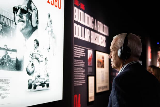 A visitor listens to the translated guided tour of the F1 Amsterdam exhibition