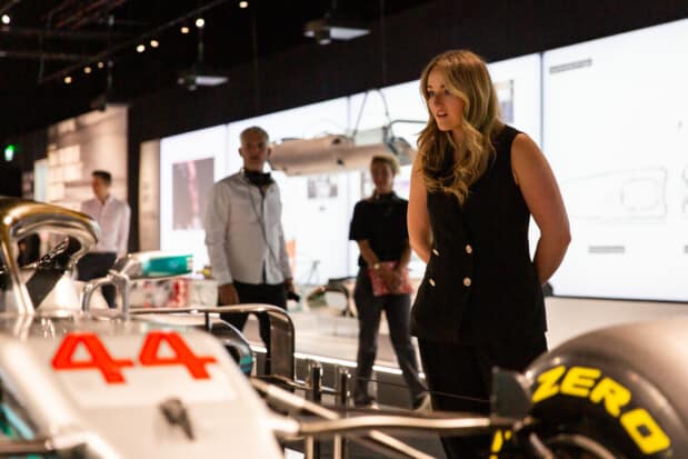 A visitor is observing a white Formula 1 single-seater, number 44